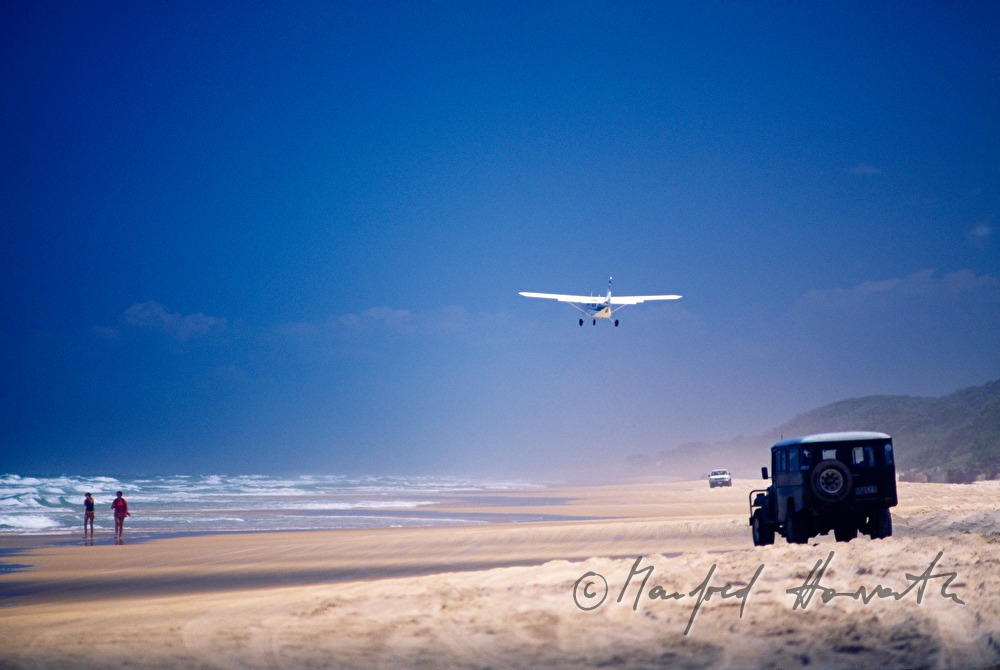 a plane lands on the beach