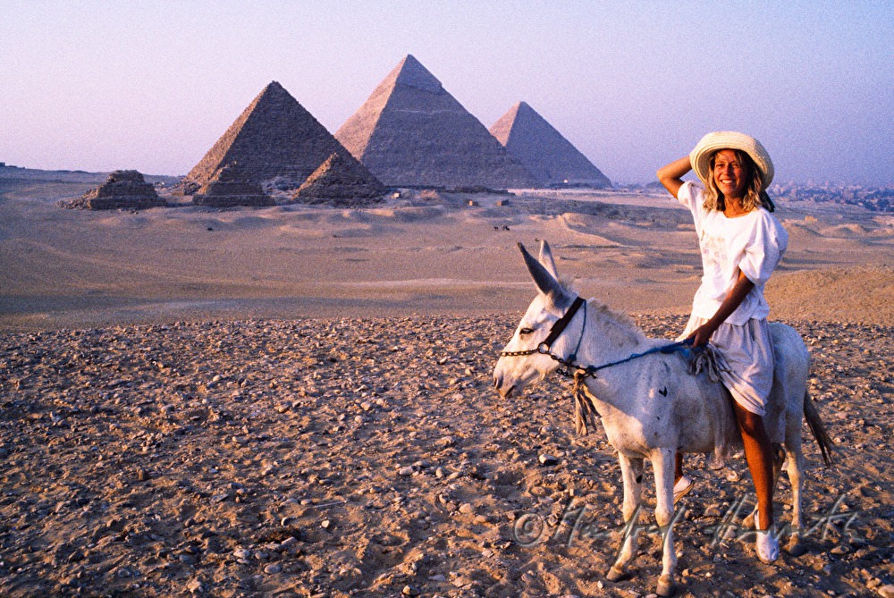 Giza Necropolis and tourist riding a donkey