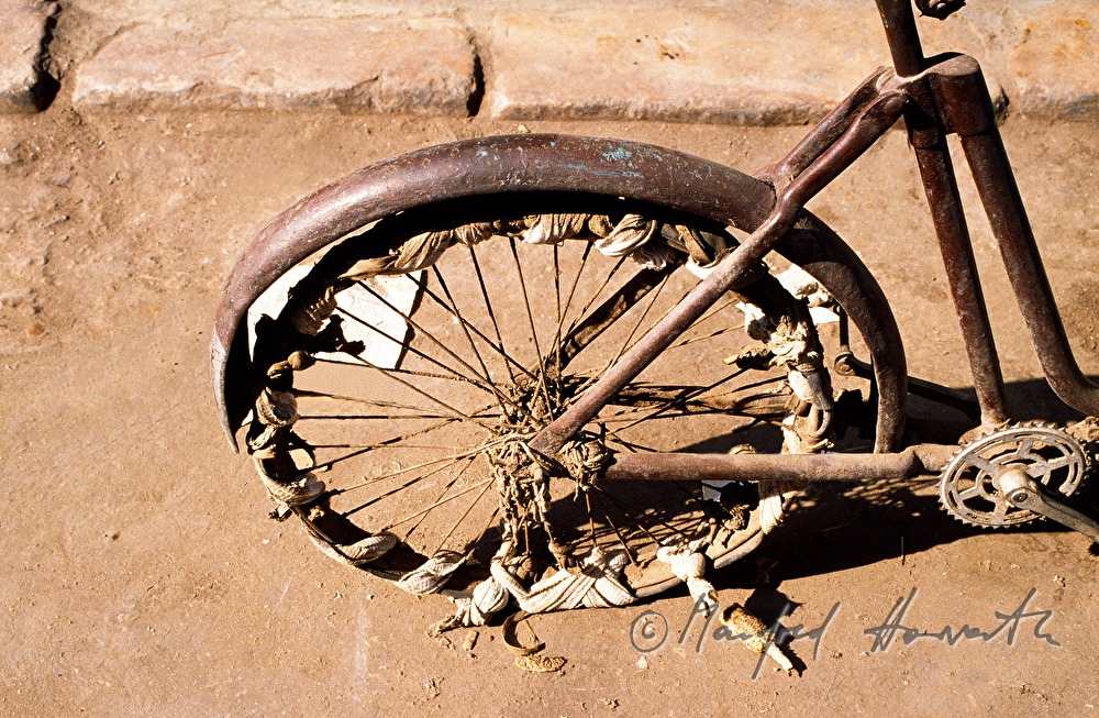 very old bicycle with patched wheel