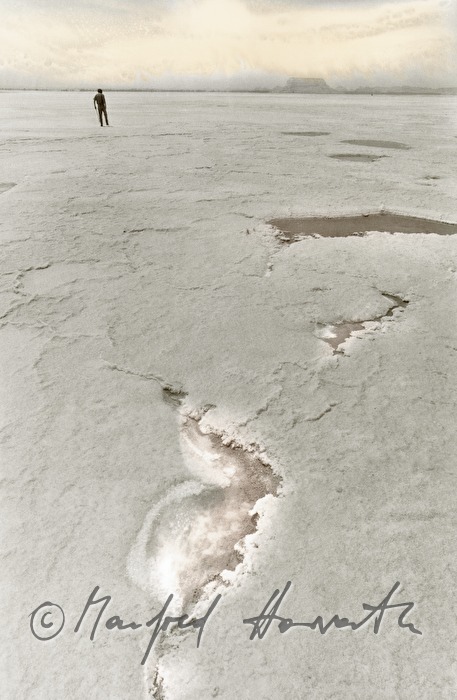 man crosses a salt lake