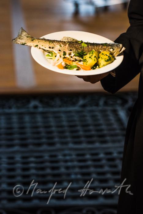monk in the dining hall with a fish dish