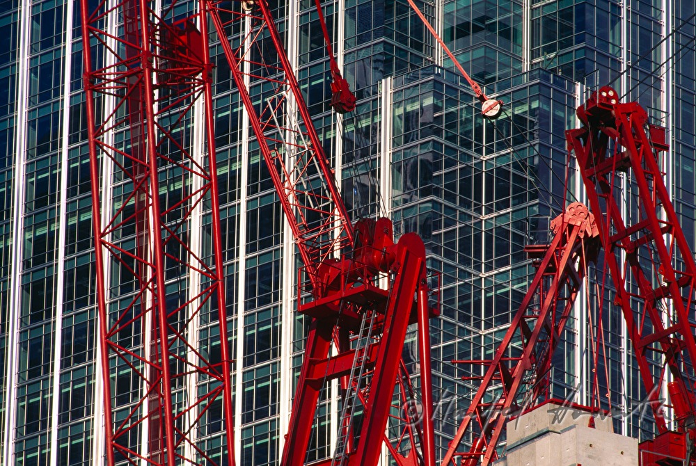 constrution cranes in front of an office building