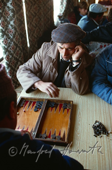 passengers in the compartment of a ferry boat play backgammon