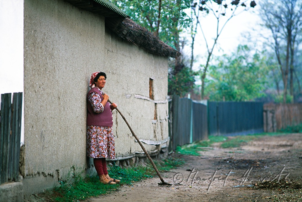 Lipovan woman with brush in front of her house