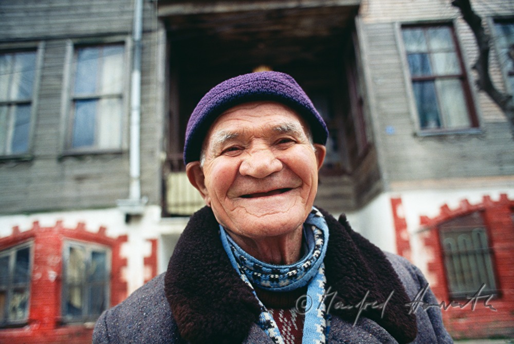 toothless man in front of a house