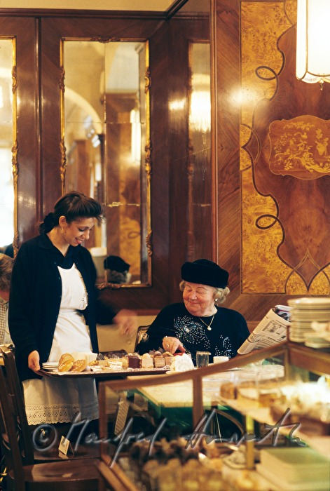 waitress offers sweets to a guest