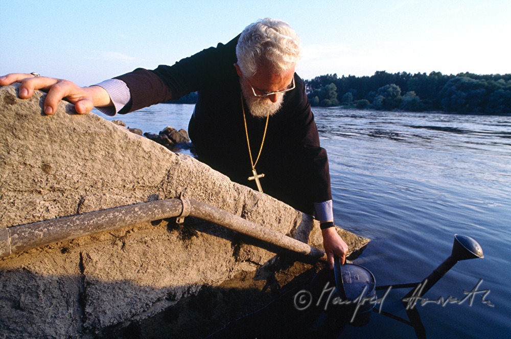 Abbot Emmanuel Jungclaussen scoops water from the Danube