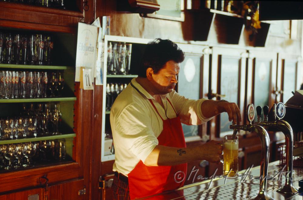 barman taping beer at the counter