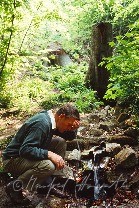 promenader refreshes himself with water from a spring