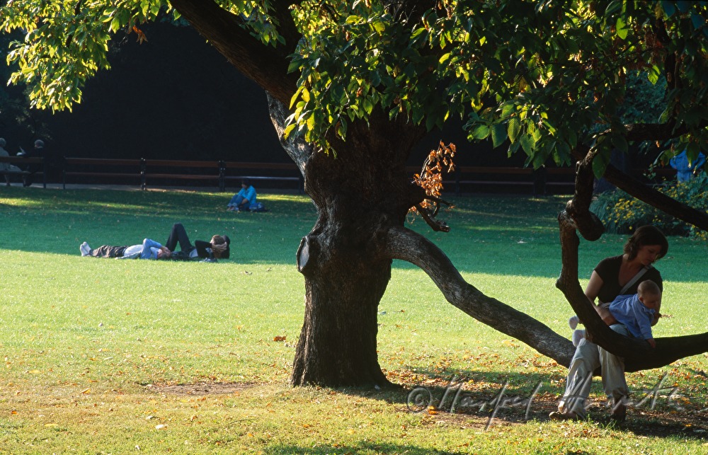 mother with baby at the lawn near the pond