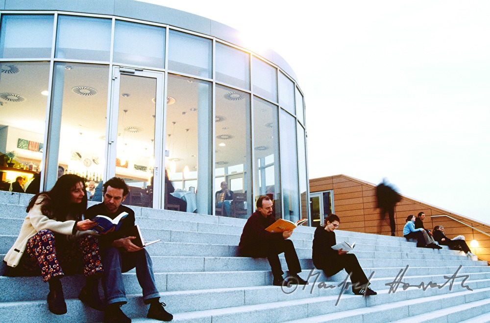 visitors of the library sit on the stairs
