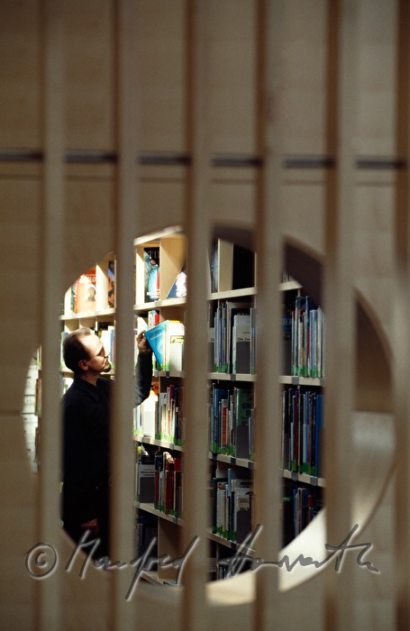 a visitor takes a book from the shelf