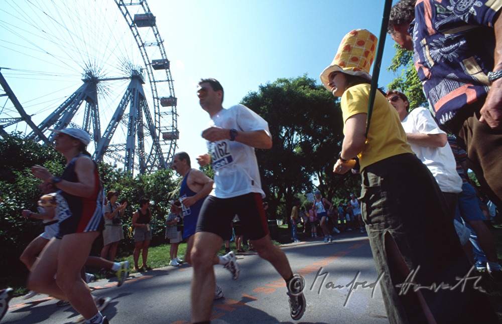 marathon runners pass the Viennese Giant Wheel