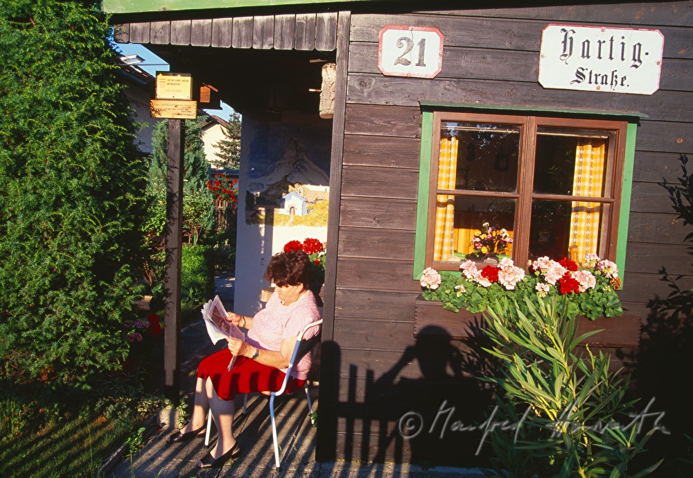 a woman reads the paper in her summer house
