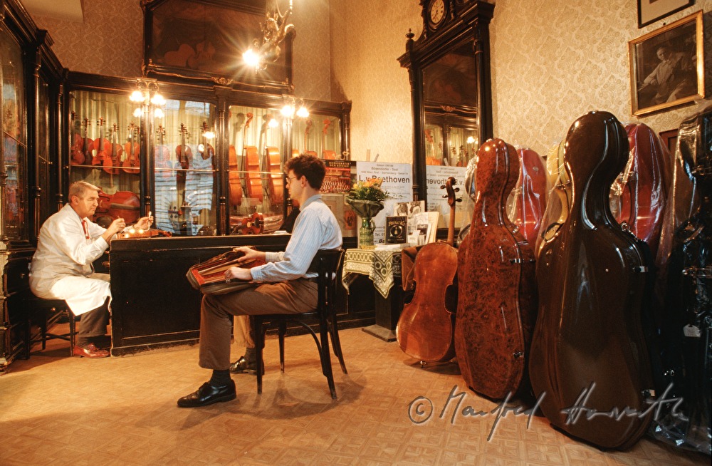 violinmaker Mr. Lang inspects a violin