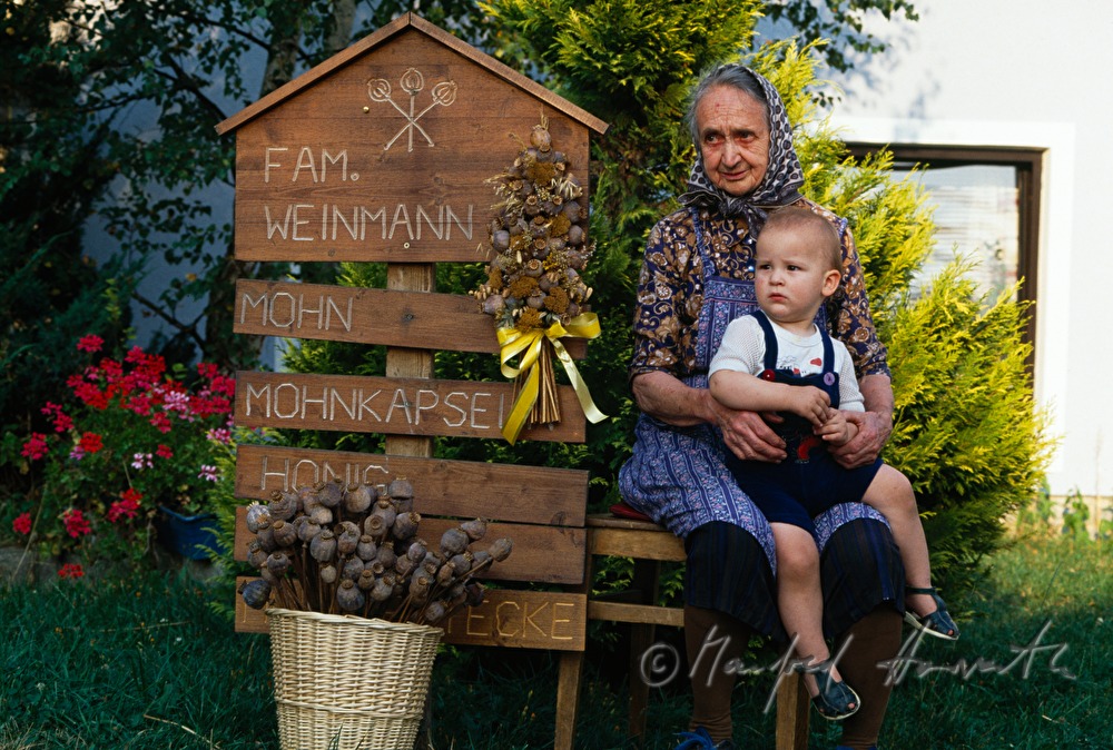 sidewalk sale of poppy capsules - granny and grandchild