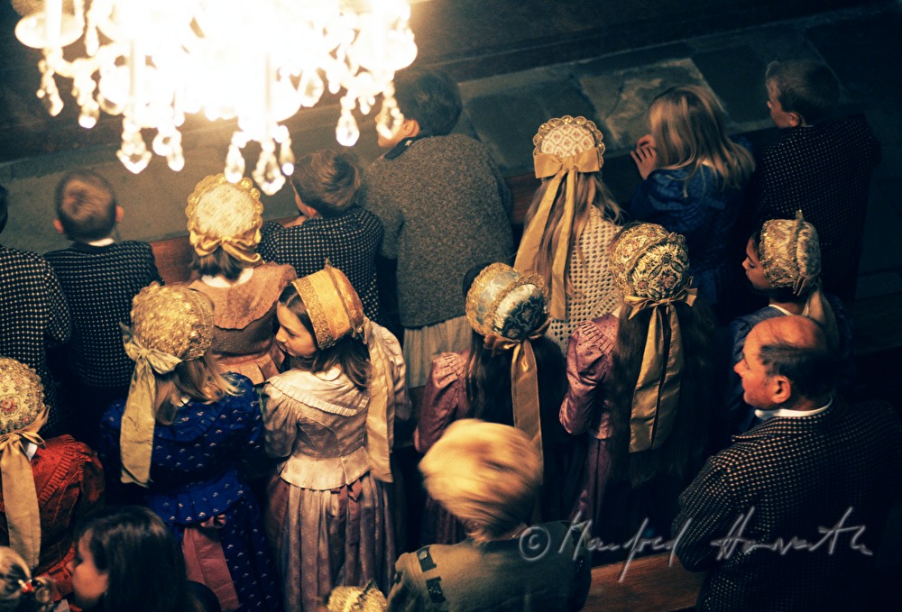 pew and people in traditional costumes