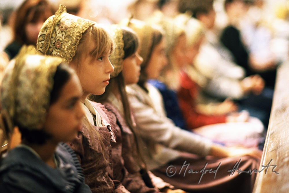 pew and children in traditional costumes
