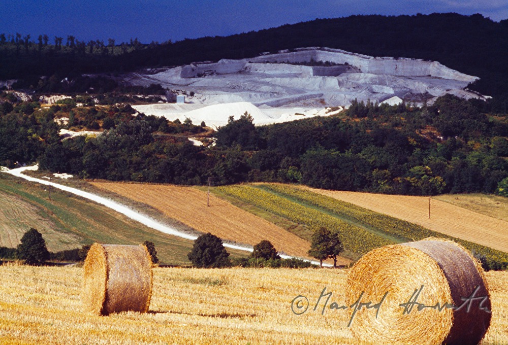 chalk quarry and bales of straw in a field