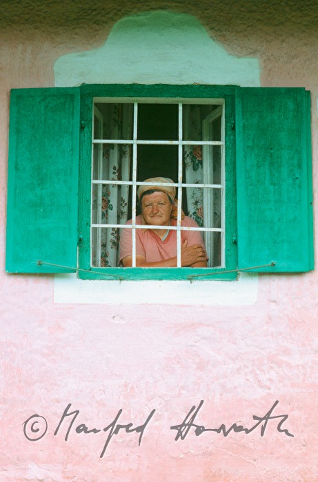 country woman looks out her window