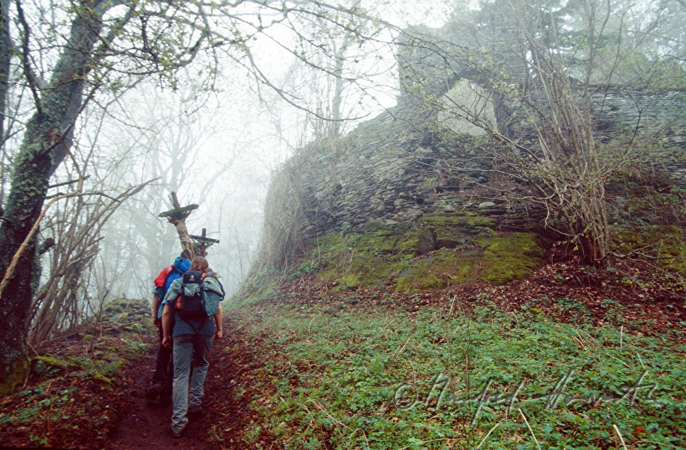 pilgrims pass a ruin of an old fortress
