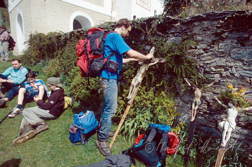 pilgrims lean their crosses to the church-wall for a break