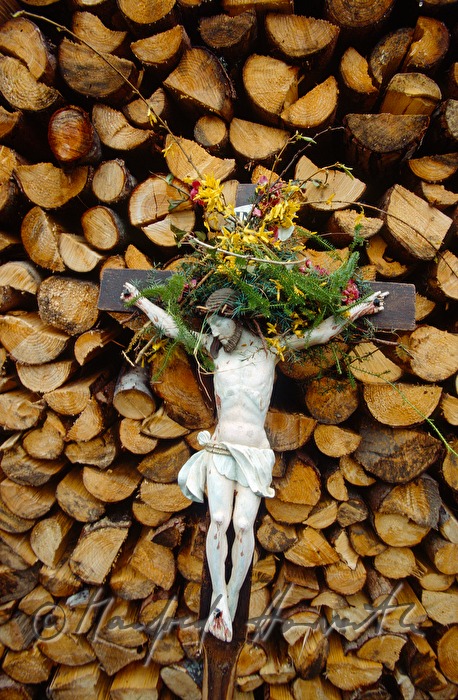 cross of a pilgrim leans on a pile of wood