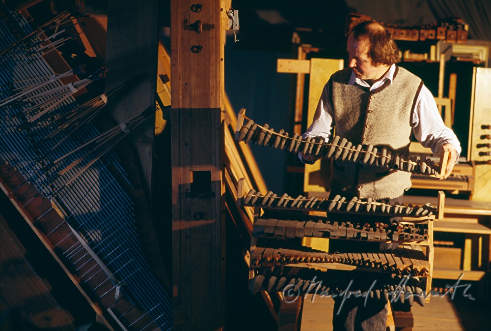 organ builder with organ pipes in the church