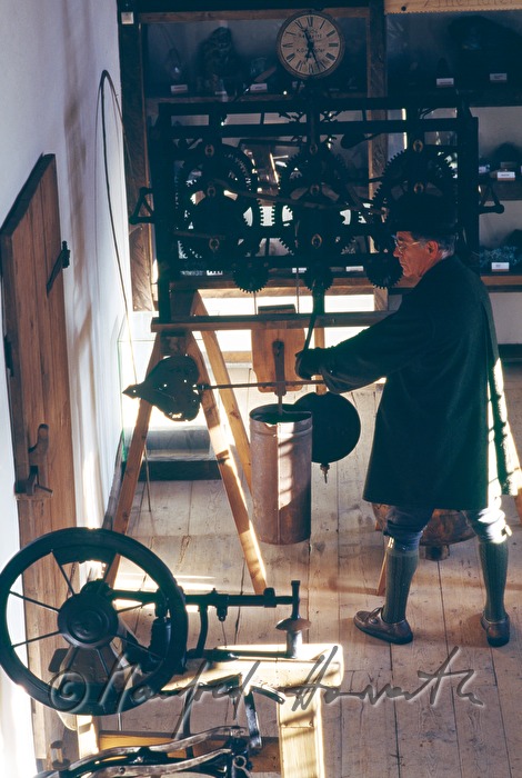 museum guide winds up a church clock