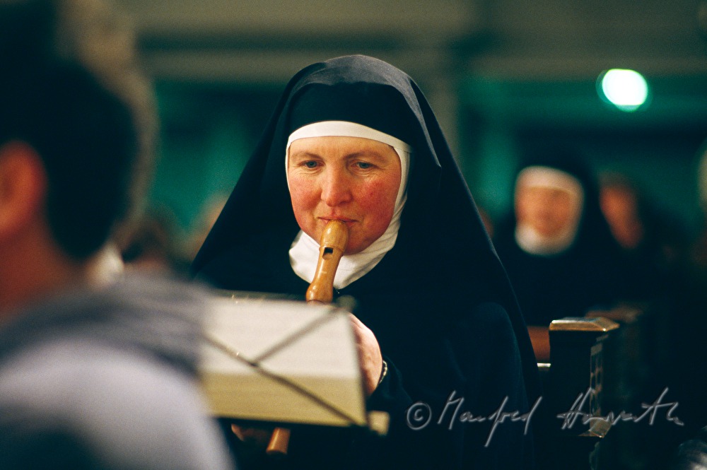 nun plays the flute in the church