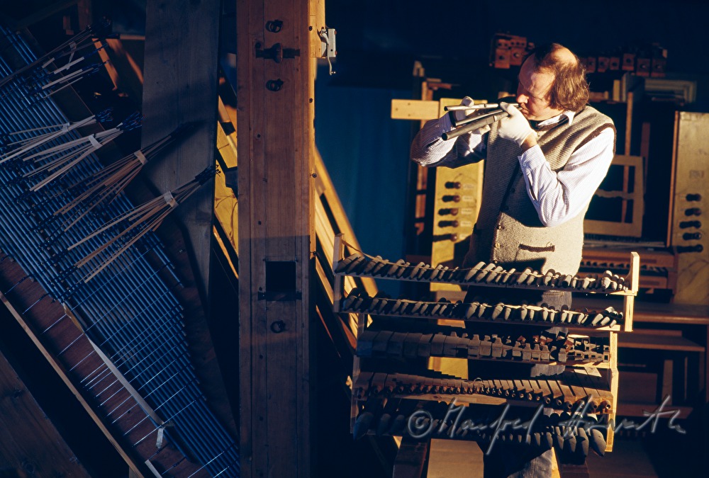 organ builder with organ pipes in the church