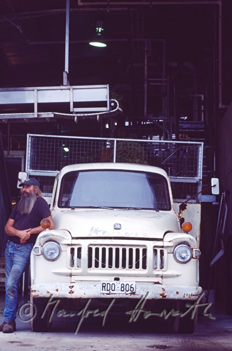 wine farmer leans on his old pickup truck