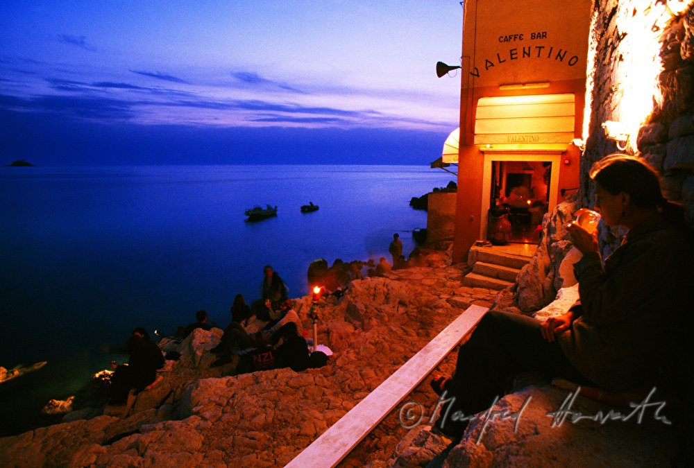 visitors sitting on the cliff with a seaview