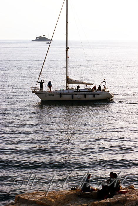 sailing boat passing an islet