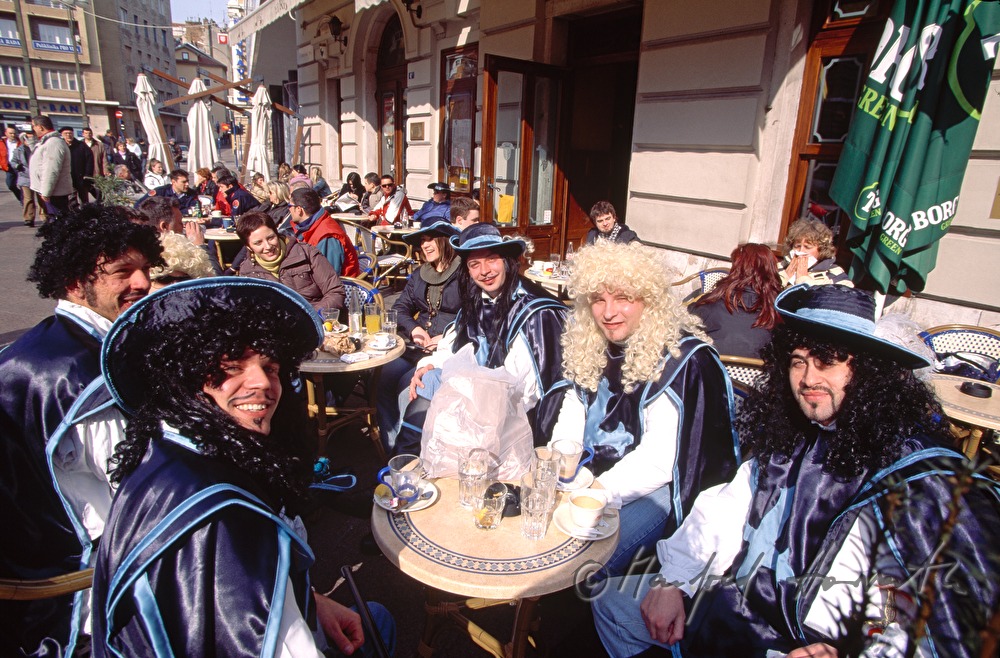 Musketeers at the carnival have a break in a cafe.