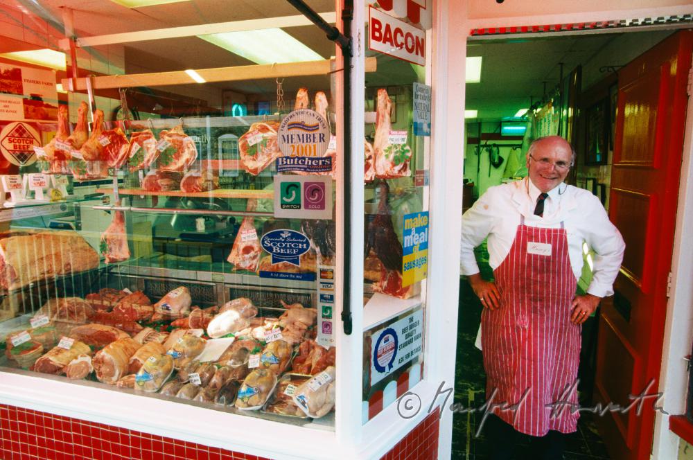 butcher in front of his store 