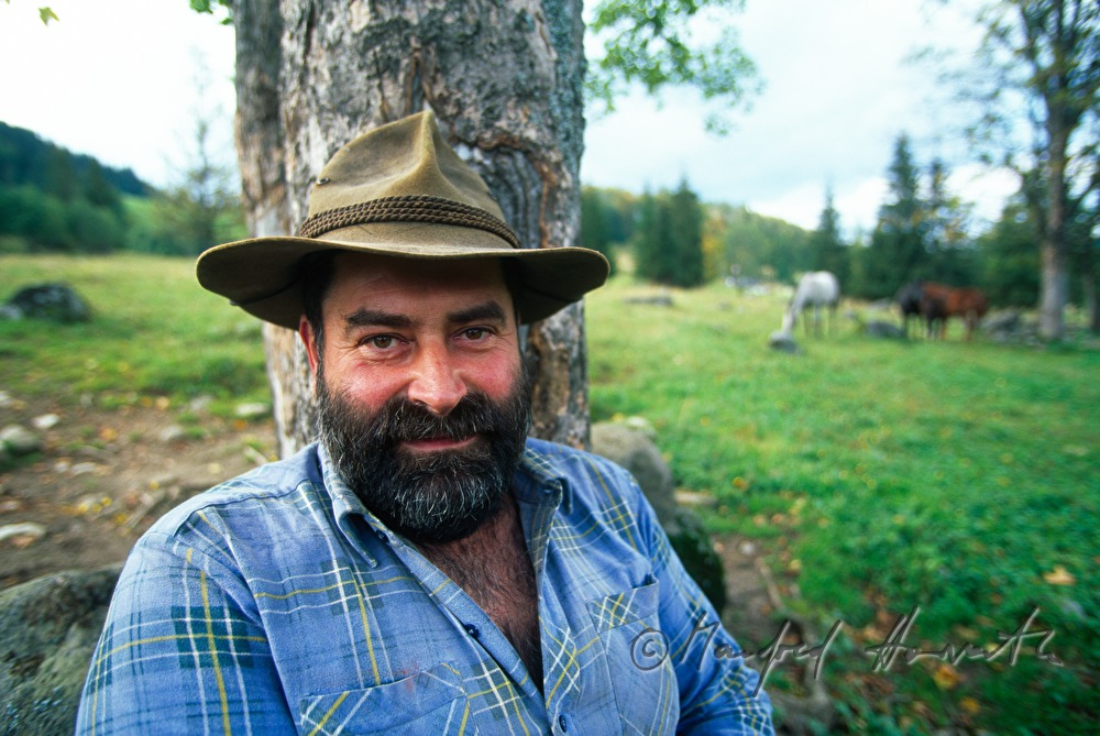 farmer leans on a tree