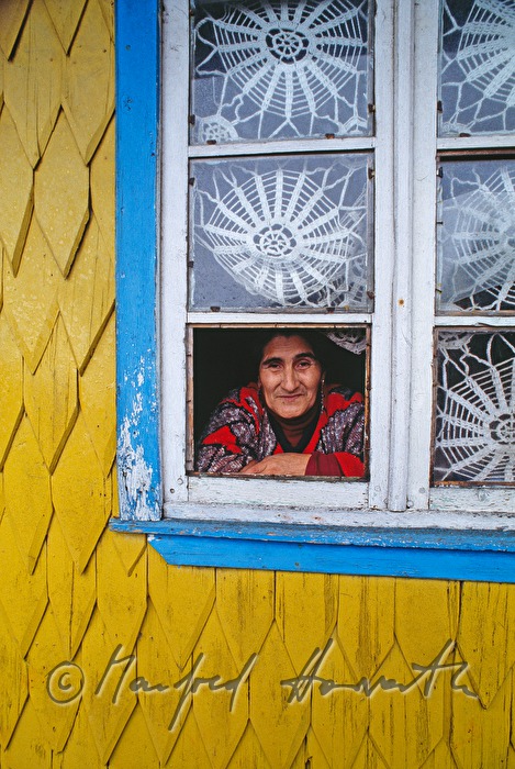 woman looks out a shingle house