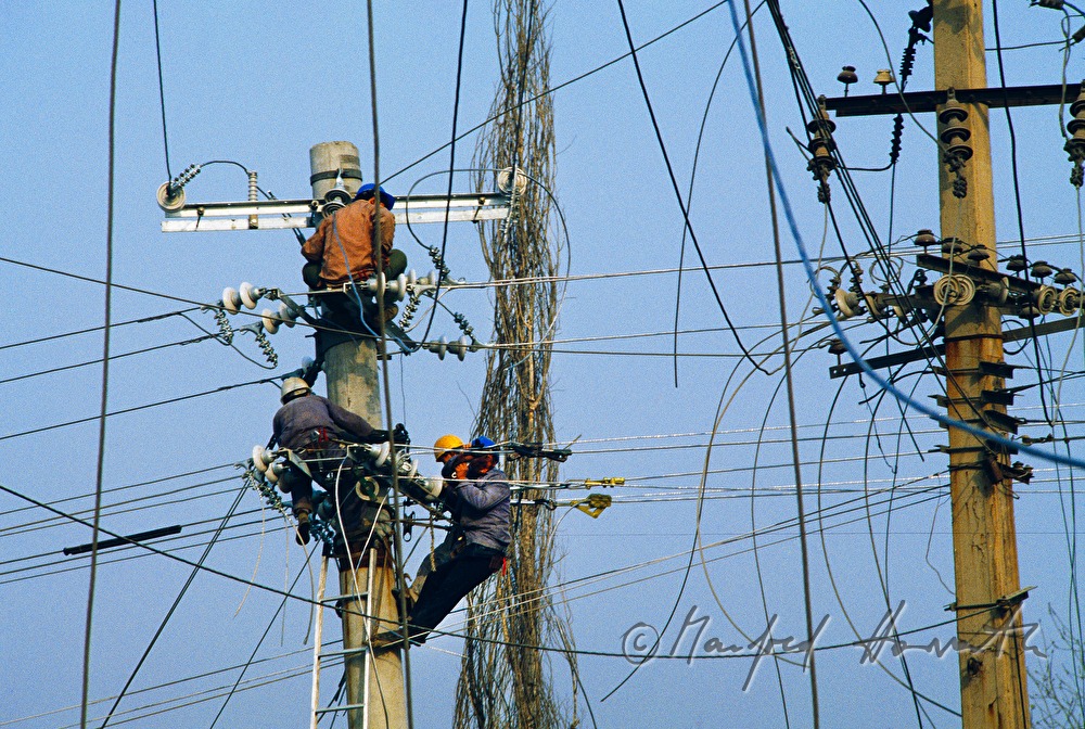 electricians working on a power pole