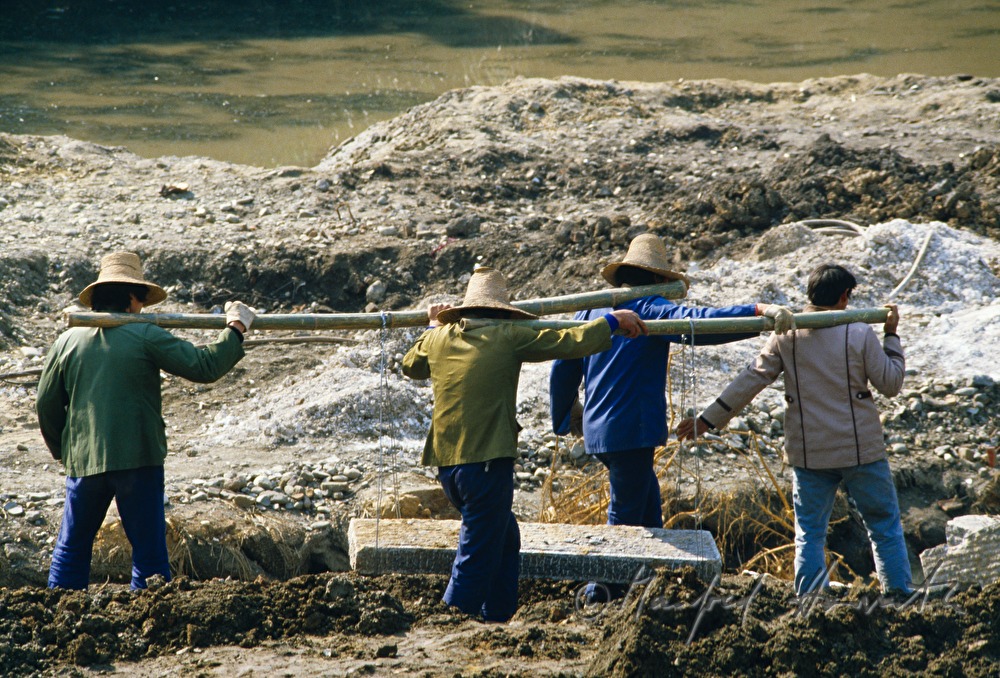 road workers carry a stone cube