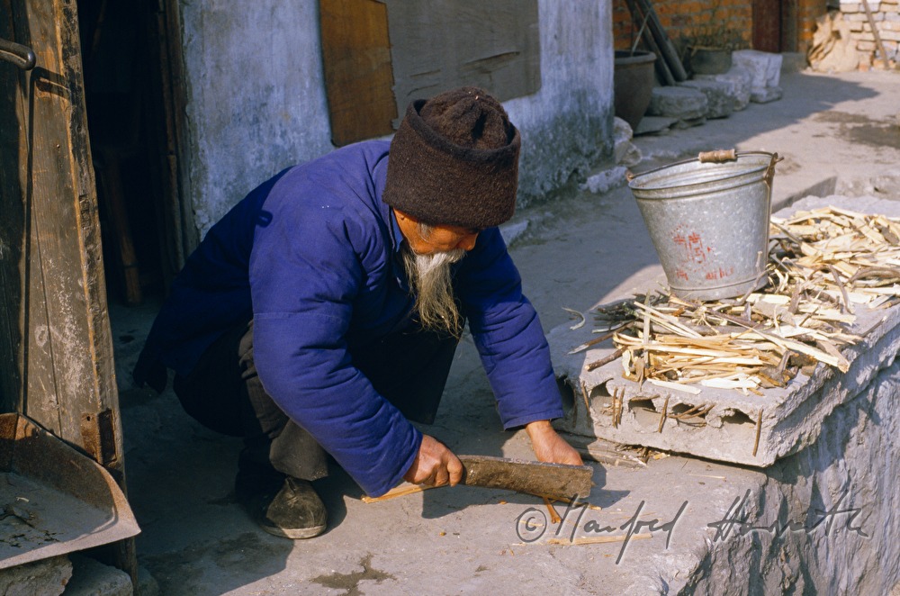 old man chops firewood