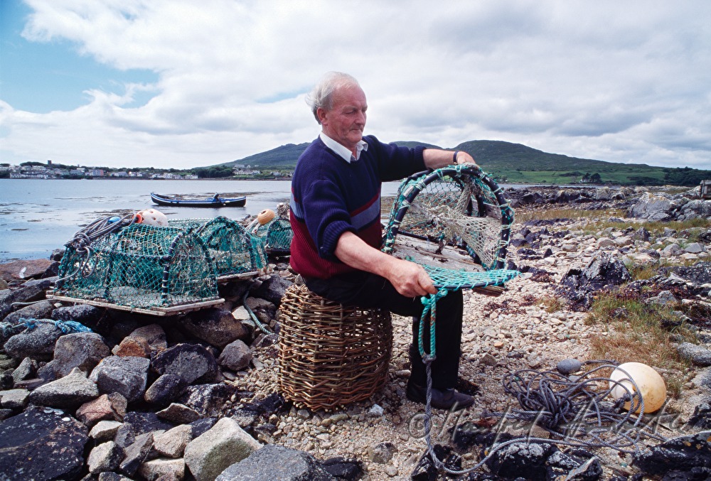 lobster fisherman with bow net on the shore