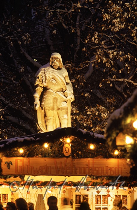 vendor stand at the christmas market and statue