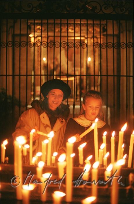 mother and daughter light a candle