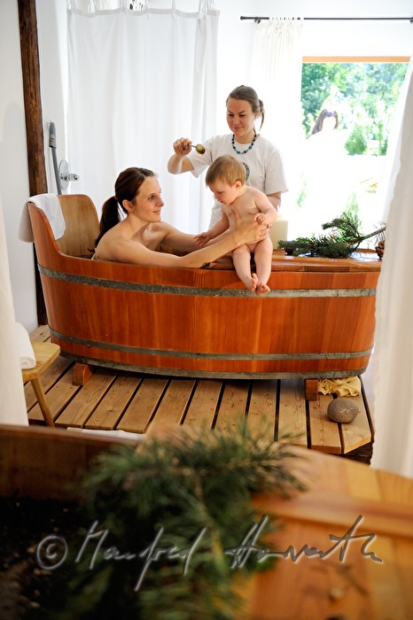 woman takes a wellness dwarf pine bath in a wooden tub
