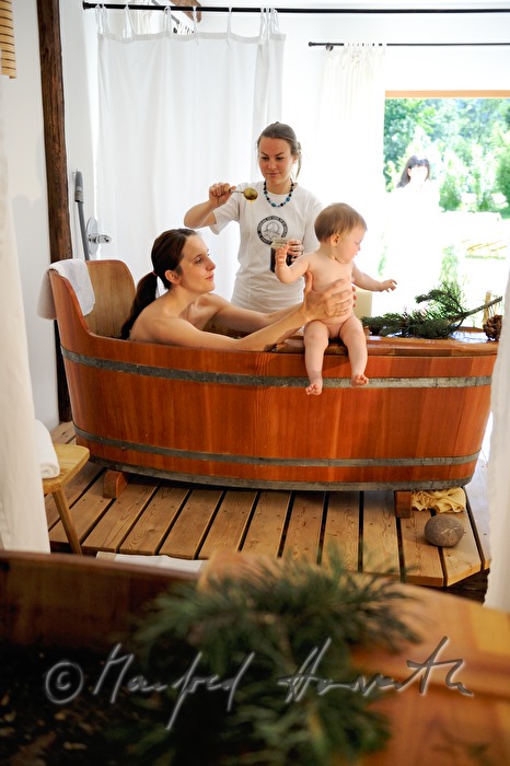 woman takes a wellness dwarf pine bath in a wooden tub