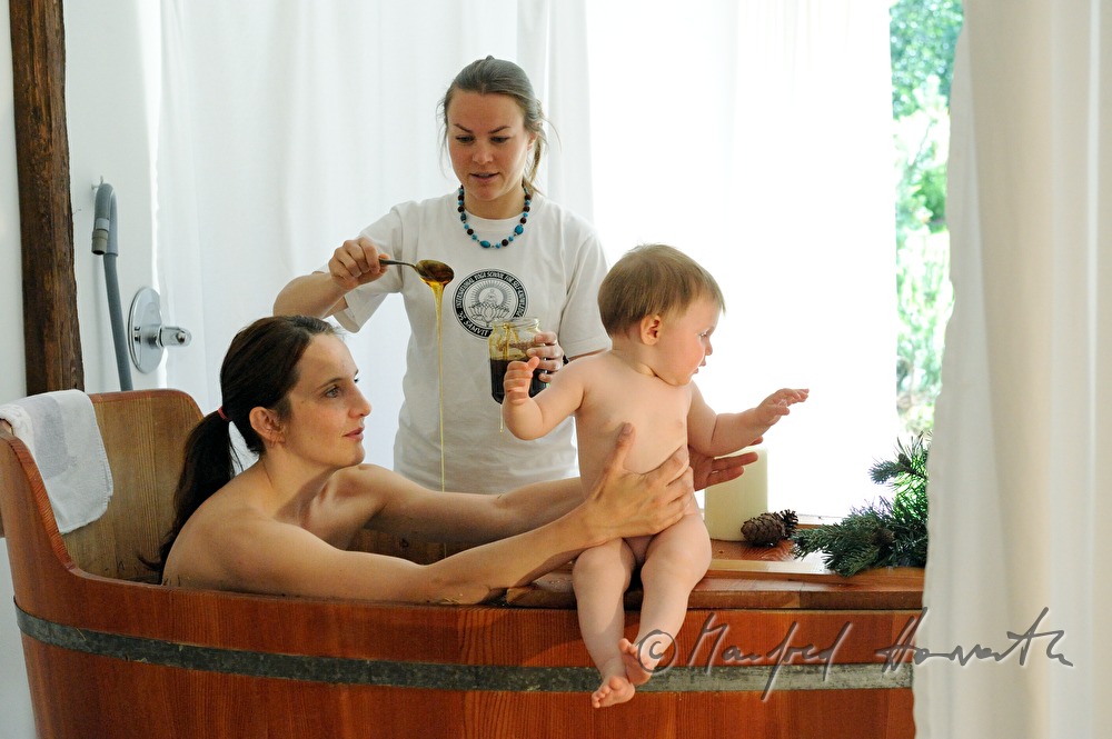 woman takes a wellness dwarf pine bath in a wooden tub
