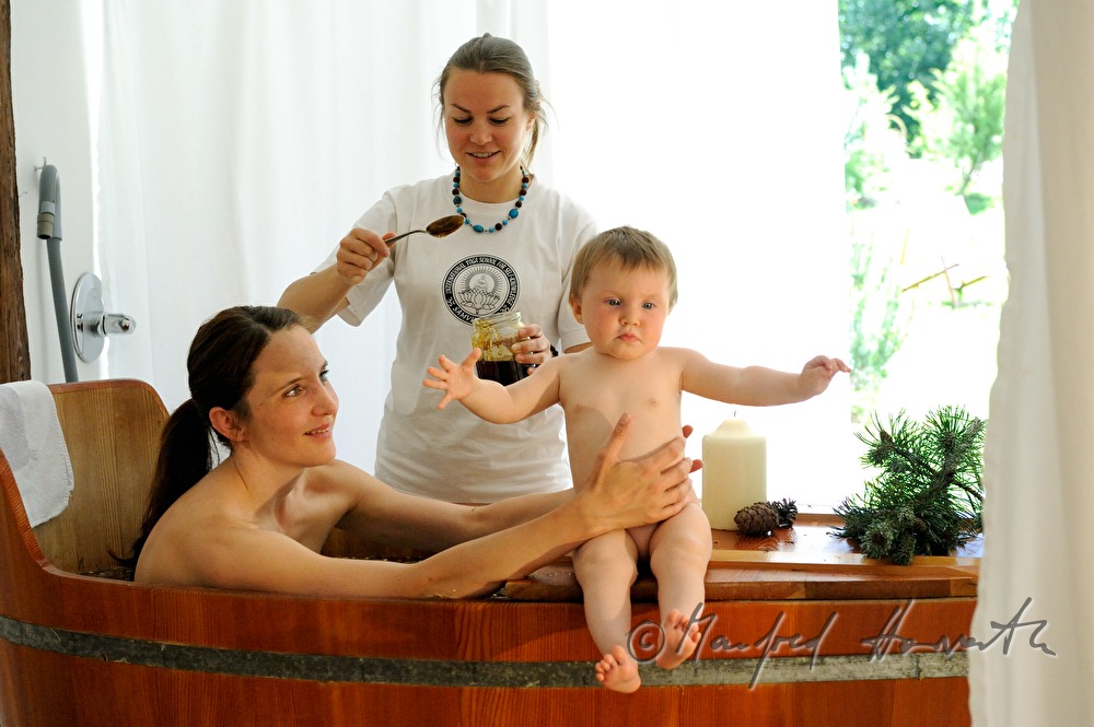 woman takes a wellness dwarf pine bath in a wooden tub