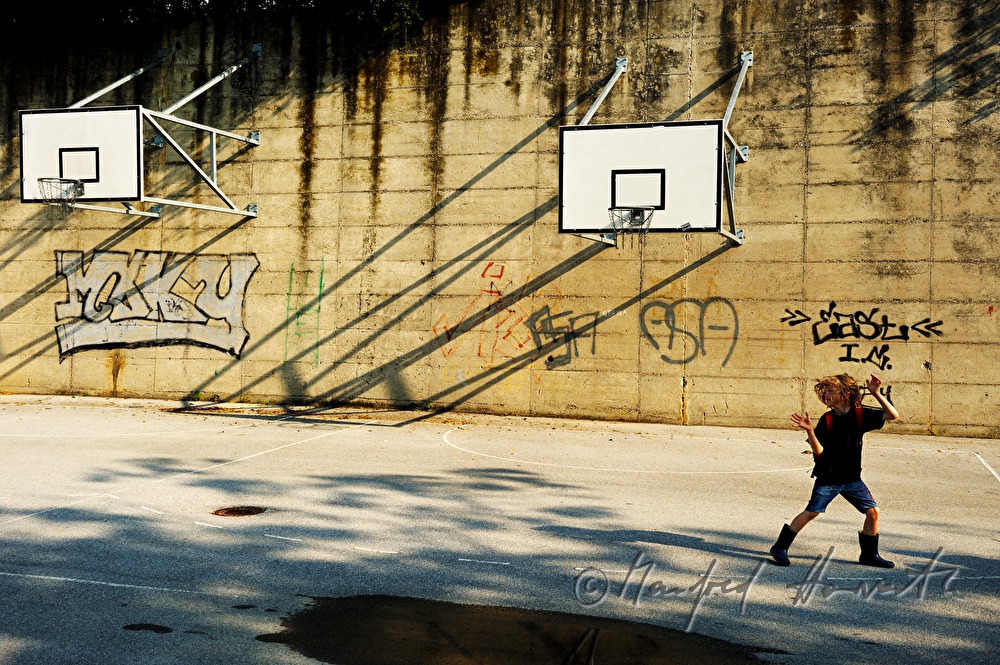 eight years old boy playing basketball