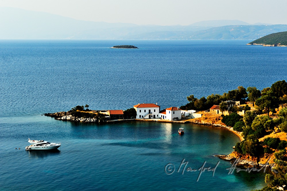 small bay with a luxury house and a yacht